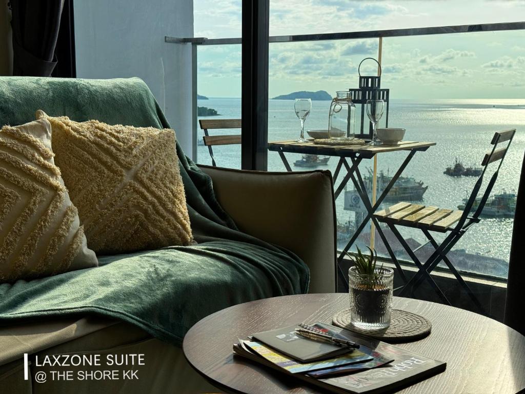 The Shore CBD Kota Kinabalu By LAXZONE SUITE في كوتا كينابالو: غرفة معيشة مع أريكة وطاولة