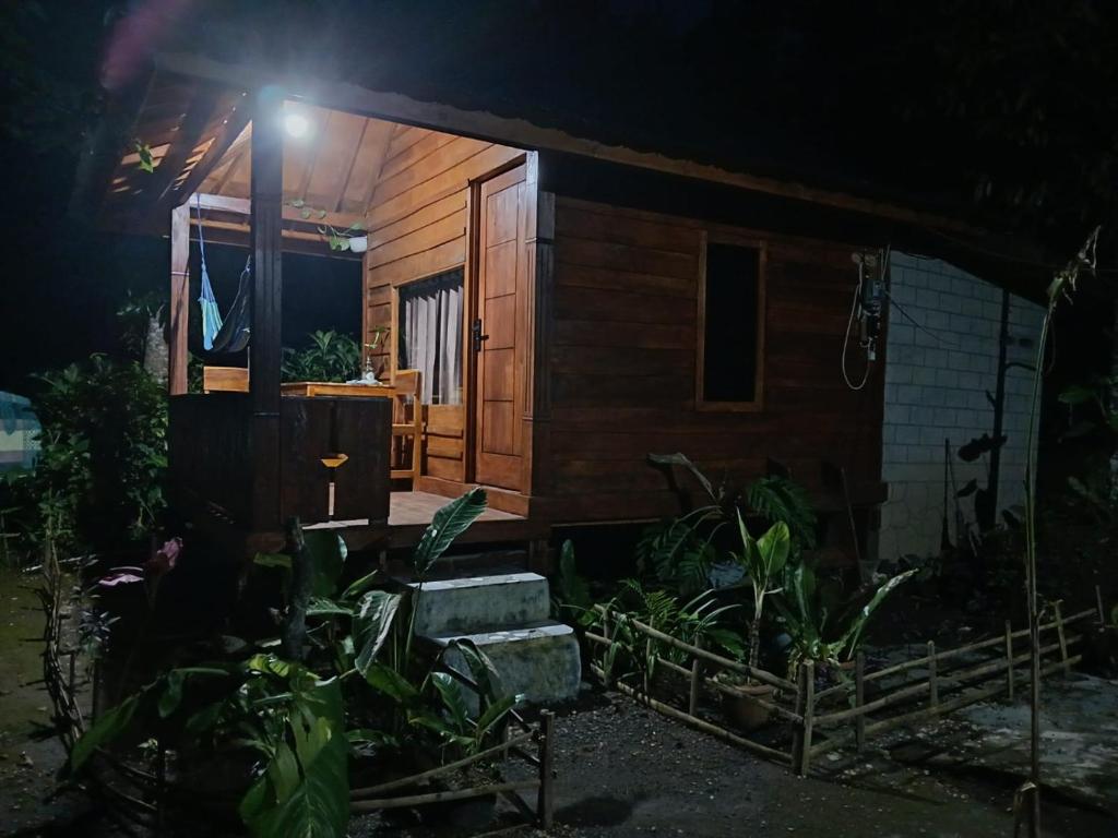 a small wooden house with a light on it at night at MY HOME tetebatu in Tetebatu
