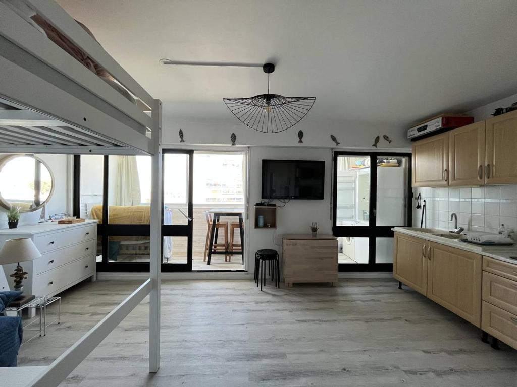 une cuisine avec des placards blancs et une chambre avec un lit dans l'établissement Studio charmant proche plage avec animaux admis - FR-1-324A-66, à Saint-Hilaire-de-Riez