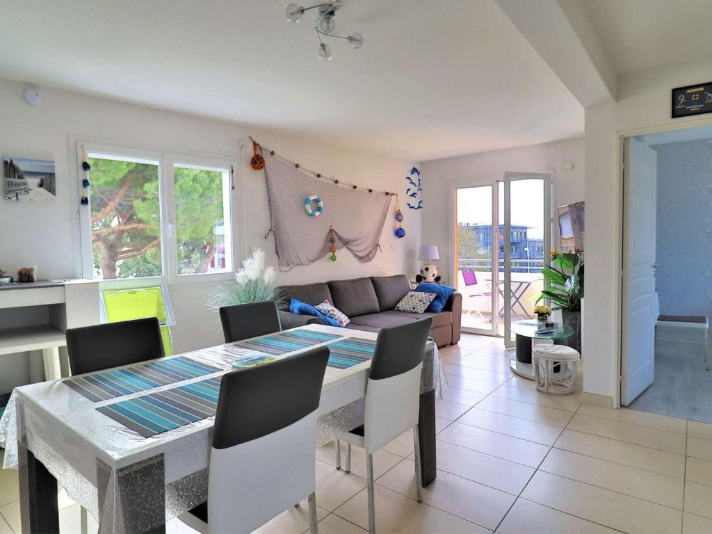 une cuisine et une salle à manger avec une table et des chaises dans l'établissement Bel appartement au centre de Royan avec balcon, garage et ascenseur - FR-1-494-188, à Royan