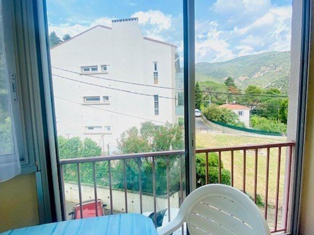 d'un balcon avec vue sur une maison blanche. dans l'établissement Studio cosy avec balcon, parking privé, proche thermes et centre ville, à Amélie-les-Bains - FR-1-703-177, à Amélie-les-Bains-Palalda