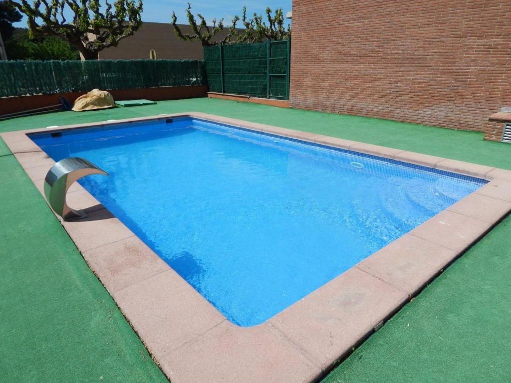 Apartamento Platja d'Aro, 2 dormitorios, 4 personas - ES-209-77 في مدريد: حمام سباحة أزرق كبير على أرضية خضراء