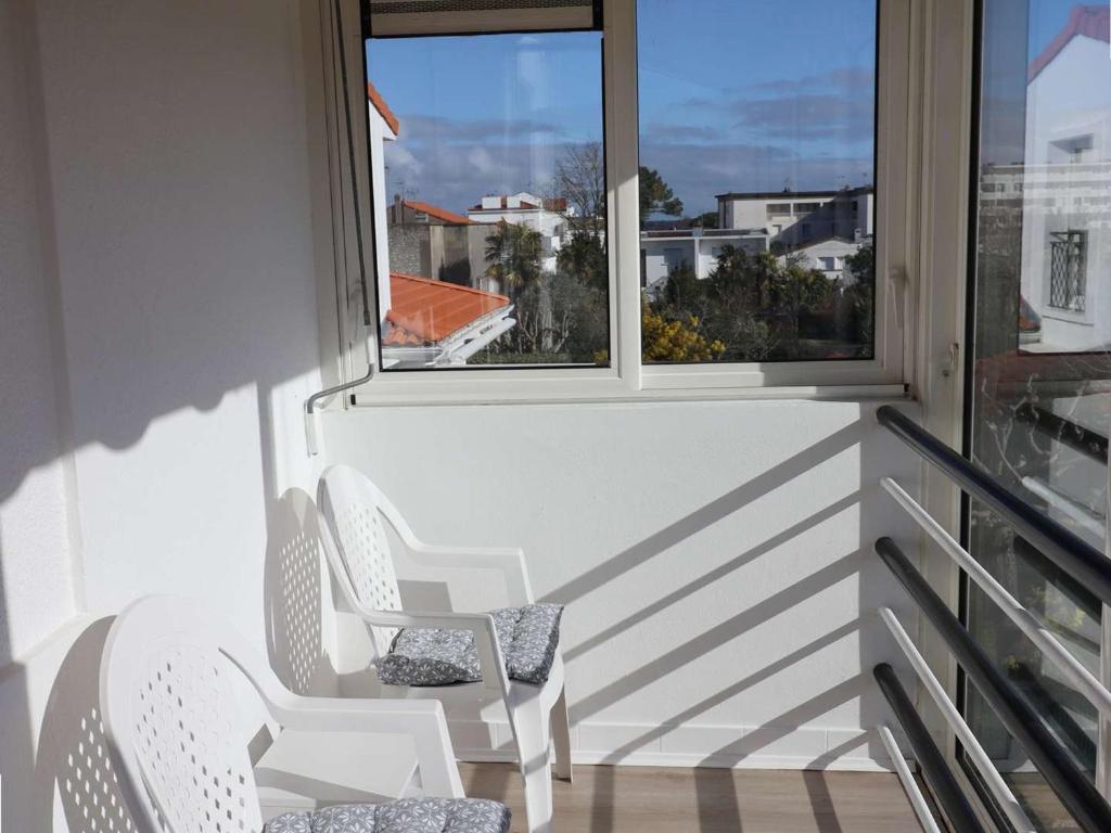 d'un balcon avec deux chaises et une fenêtre. dans l'établissement Appartement Royan, 2 pièces, 2 personnes - FR-1-494-187, à Royan