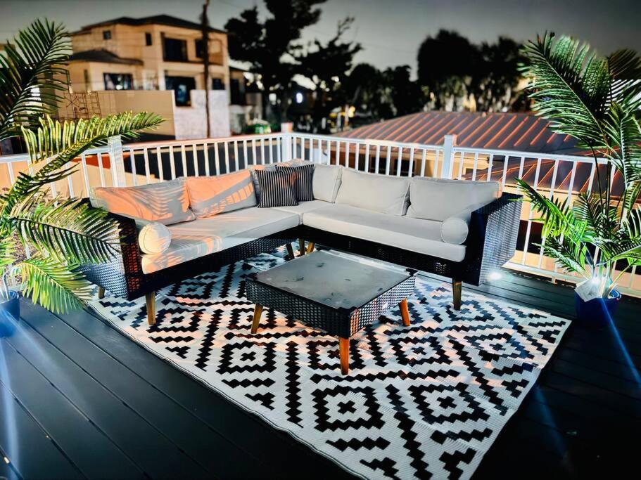 patio z kanapą i stołem na pokładzie w obiekcie Oceanview Retreat/Perfect for Groups/Heated Pool w mieście Fort Myers Beach