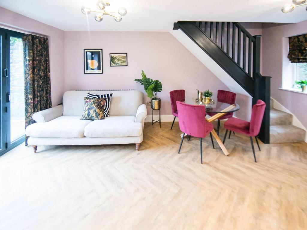 sala de estar con sofá blanco y sillas rosas en The Soloman Suite - Ukc6701, en Buxton