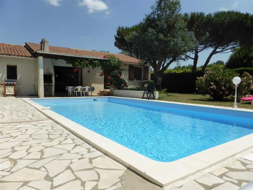 - une piscine en face d'une maison dans l'établissement Villa La Palmyre, 4 pièces, 7 personnes - FR-1-705-67, aux Mathes