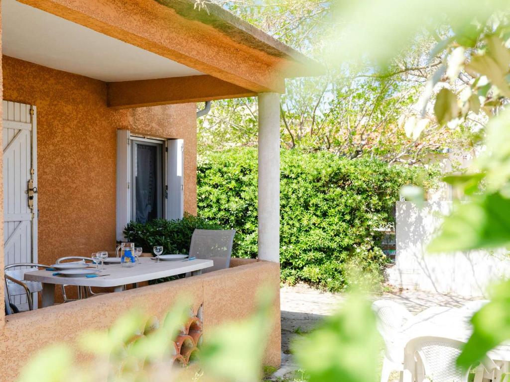 d'une terrasse avec une table et un ordinateur portable. dans l'établissement Maison de vacances à 300m de la plage avec 3 chambres, parking privé et jardin équipé - FR-1-409-267, à Fleury