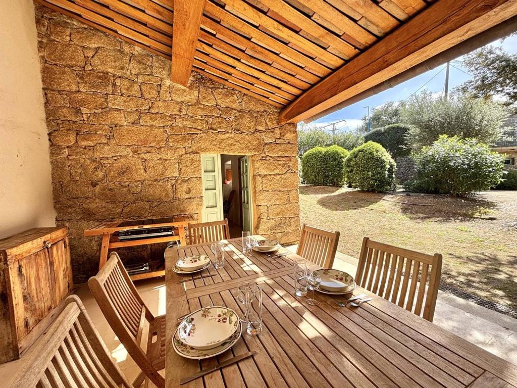 einen Holztisch und Stühle auf einer Terrasse in der Unterkunft Maison Pietrosella, 3 pièces, 4 personnes - FR-1-61-631 in Pietrosella