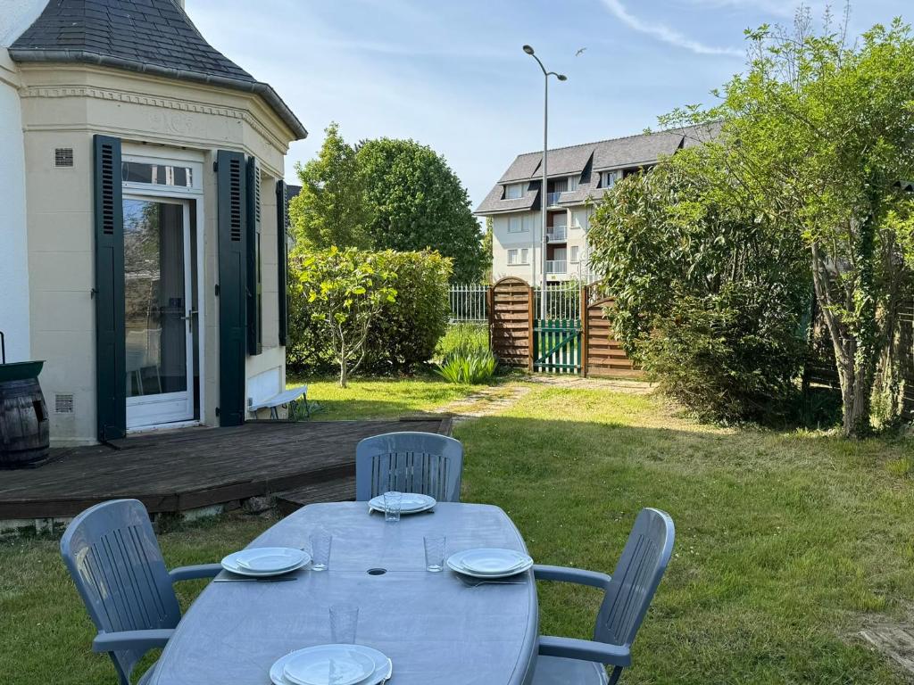 - une table et des chaises dans la cour d'une maison dans l'établissement Grand 3P avec Jardin, Proche Centre, Calme – Cabourg - FR-1-487-367, à Cabourg