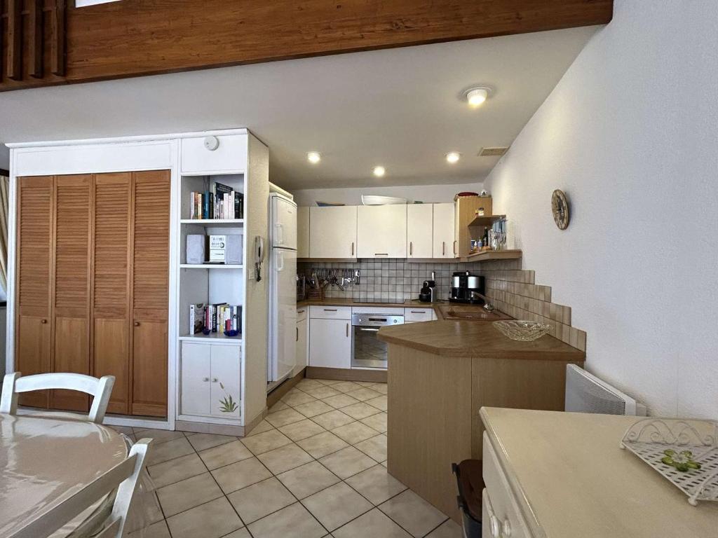 Una cocina con gabinetes blancos y encimera. en Duplex central à Banyuls-sur-Mer, 4 couchages, plage et commerces à proximité - FR-1-225C-141, en Banyuls-sur-Mer
