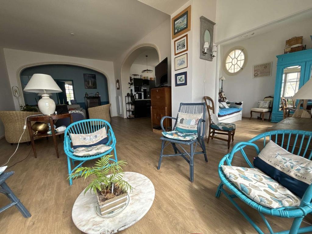 un salon avec des chaises bleues et une table dans l'établissement Bel appartement avec parking à Royan - FR-1-494-189, à Royan