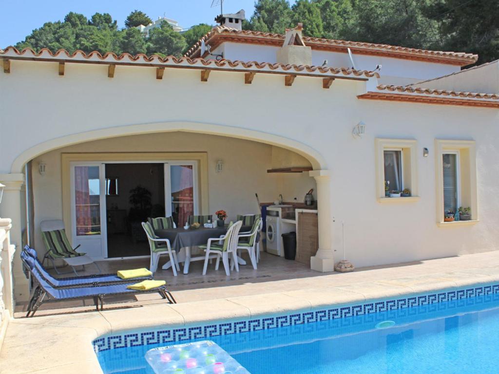 uma villa com uma piscina e uma casa em Villa Moraira, 3 pièces, 4 personnes - HISP-216-216 em Teulada