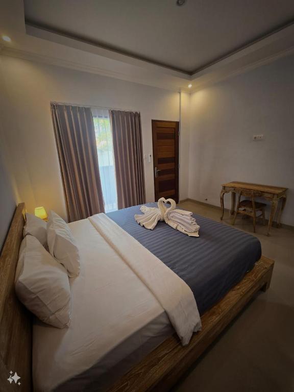a bedroom with a large bed with towels on it at The Lucky Canggu 2 in Canggu