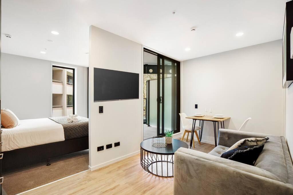 a living room with a couch and a bed and a table at Modern 1-Bedroom City Centre in Auckland