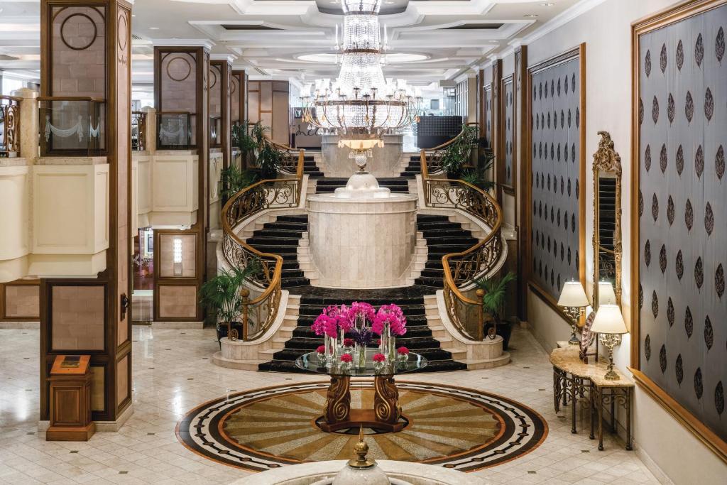 a hallway with a large staircase with a fountain at The Langham Melbourne in Melbourne