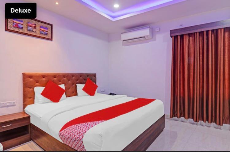 een slaapkamer met een groot bed met rode kussens bij Hotel SS PALACE in Lucknow