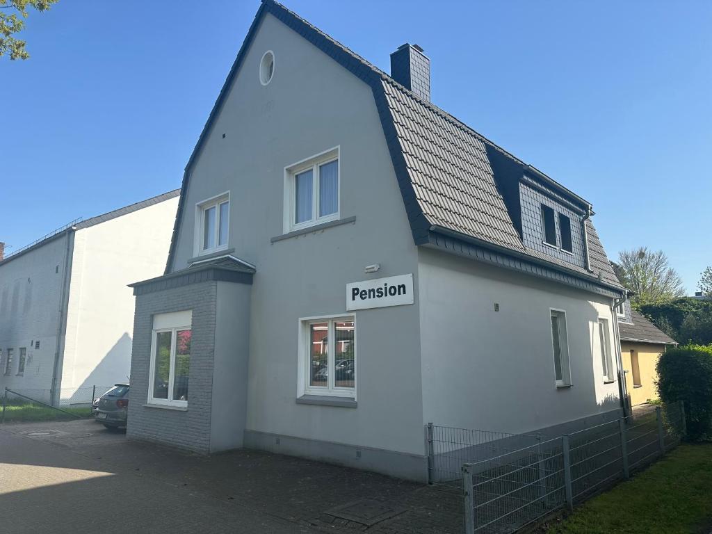 uma casa branca com um sinal que lê paixão em Die kleine Pension em Delmenhorst