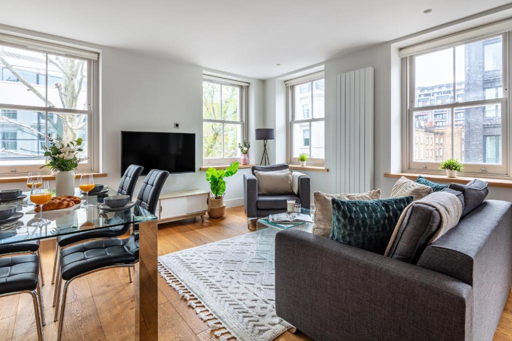 a living room with a couch and a table at Central Fitzrovia - CityApartmentStay in London