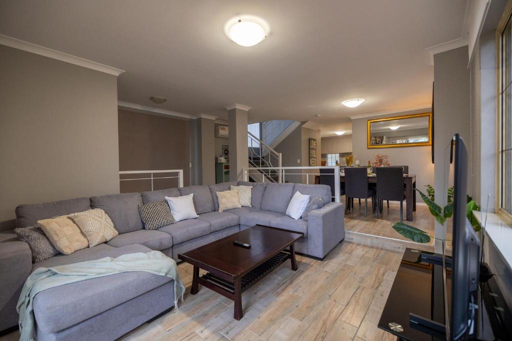 ein Wohnzimmer mit einem Sofa und einem Tisch in der Unterkunft Urban Oasis Hideaway in Perth