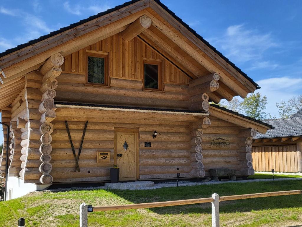 una cabaña de madera con techo de gambrel en Böhmerwald Lodges en Ulrichsberg