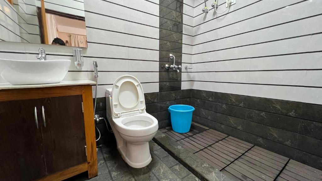 a bathroom with a toilet and a sink at Kutumba Kutir in Mirik