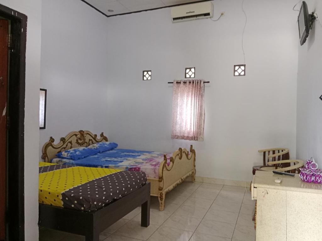 1 Schlafzimmer mit 2 Betten in einem Zimmer in der Unterkunft Wisma Anugerah Jaya in Bira