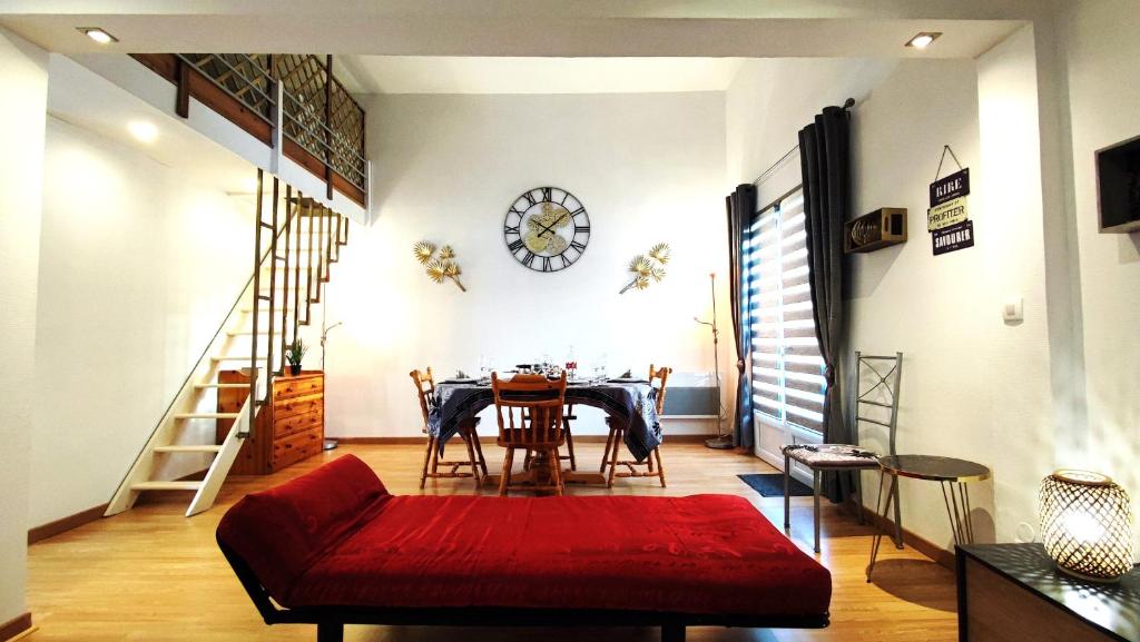 une salle à manger avec une table et un canapé rouge dans l'établissement MezzaLoft, appartement 78m2, à Saint-Pierre