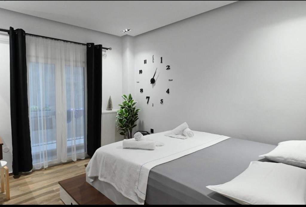 een slaapkamer met een bed en een klok aan de muur bij Thessaloniki Amazing Apartment in Thessaloniki