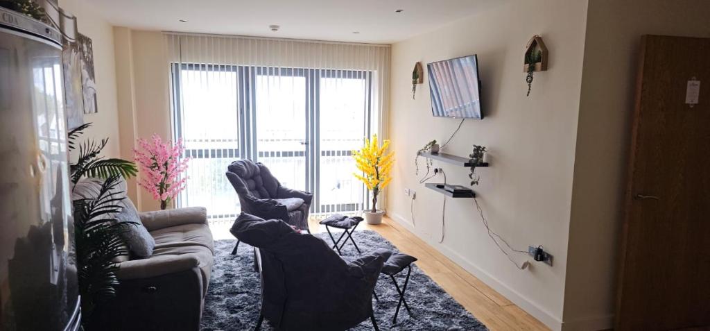 ein Wohnzimmer mit 2 Sofas und einem großen Fenster in der Unterkunft Spacious 2BDR Flat for 5 in City Centre in Liverpool