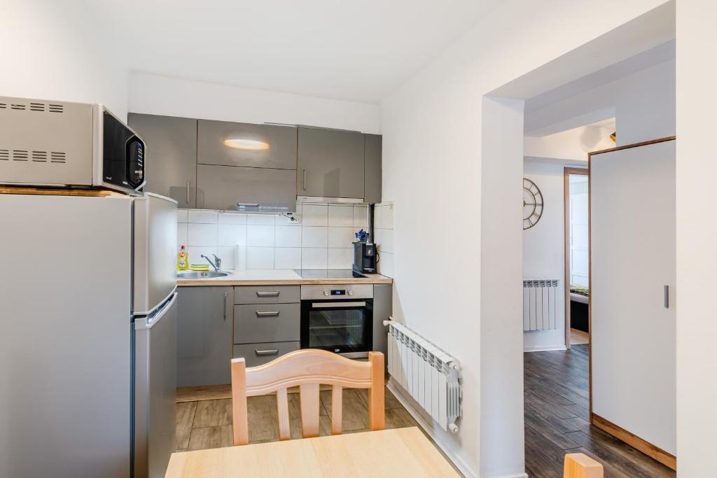 a kitchen with stainless steel appliances and a wooden table at Penzion Hosnar, apartma Lev in Bovec