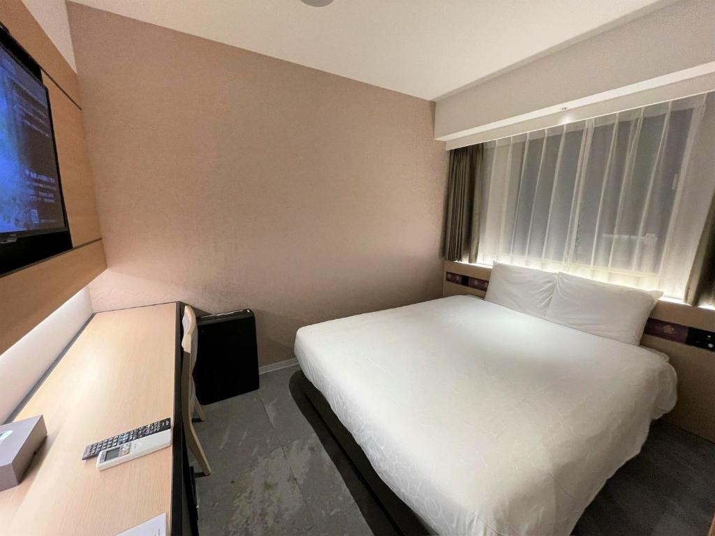 a hotel room with a bed and a flat screen tv at Henn na Hotel Premier Nara in Nara