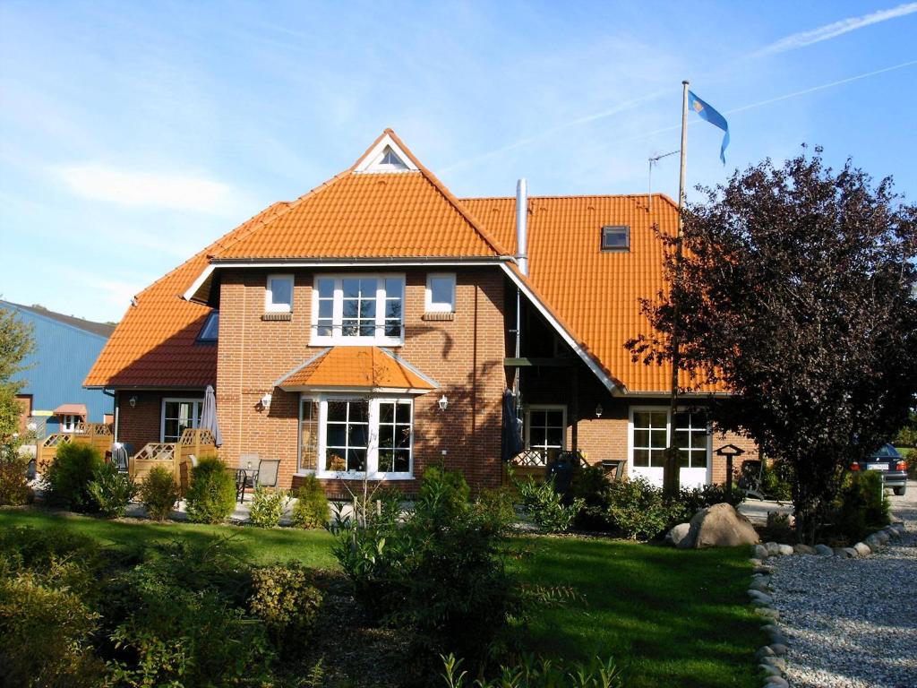 a large brick house with an orange roof at Ferienhof Christian und Antje Hopp in Fehmarn