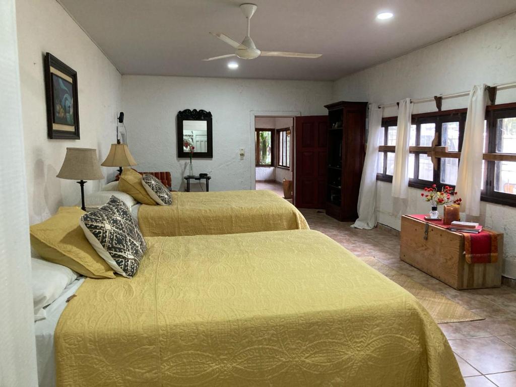sypialnia z 2 łóżkami i wentylatorem sufitowym w obiekcie Rural cotage and sandy bay w mieście Tela