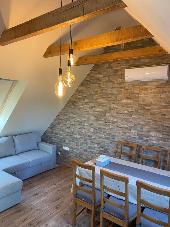 un soggiorno con un divano, un tavolo e delle sedie di Klebi’s Apartmanház 20 a Balatonföldvár