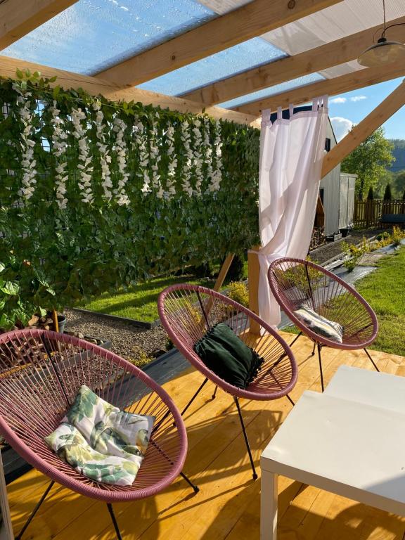 a group of chairs and tables on a patio at Bieszczadzkie BOHO stodoły z jacuzzi i sauna na wyłączność in Myczkowce