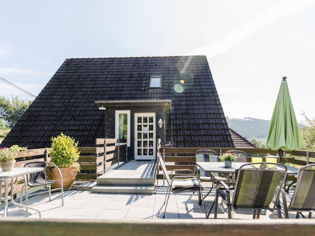 eine Terrasse mit Tischen und Stühlen und ein Haus in der Unterkunft House on the sunny slope type C in Eslohe