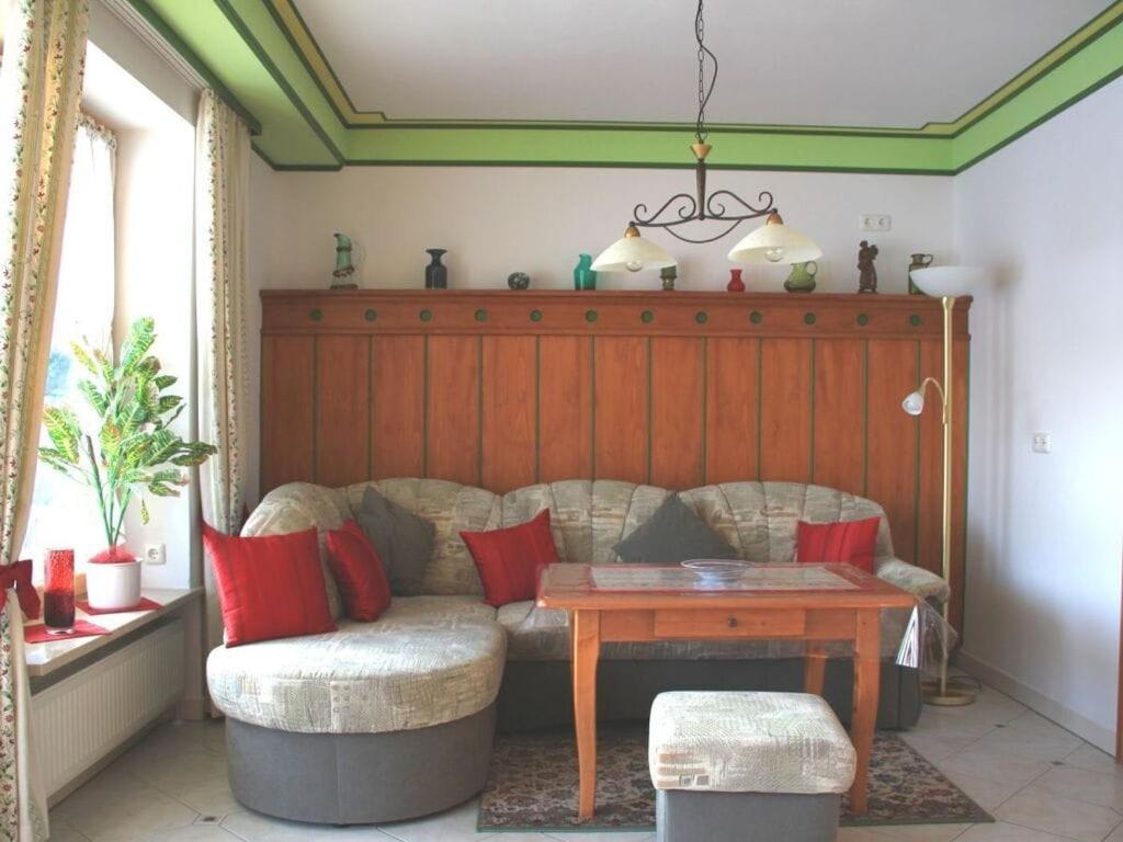ein Wohnzimmer mit einem Sofa und einem Tisch in der Unterkunft Holiday apartment 1S oak grove in Lindberg