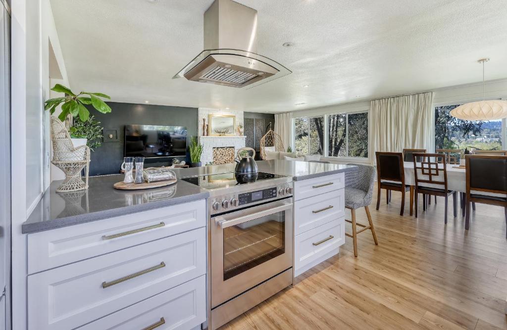 una cucina con armadi bianchi e una sala da pranzo di Zen Haus, Spacious Retreat, luxury, near UO a Eugene
