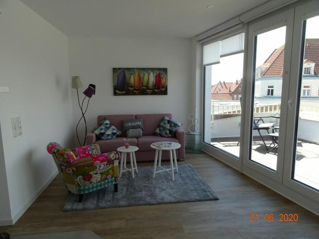 uma sala de estar com um sofá e uma mesa em Old Printing House Holiday Apartment Cicero em Norderney