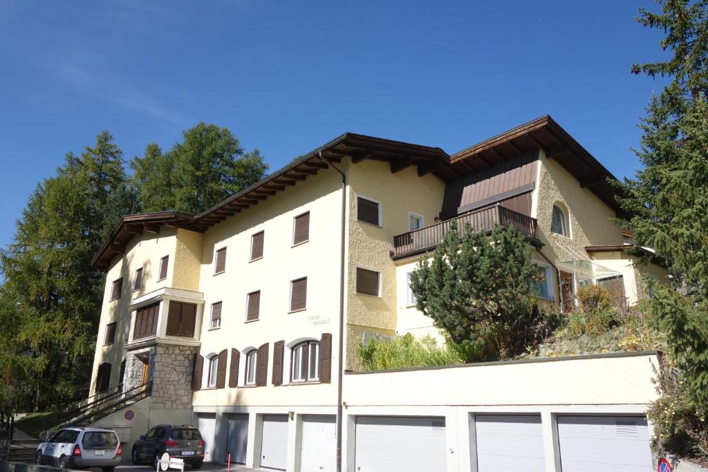 a white building with a brown roof at Chesa Muragls in Pontresina