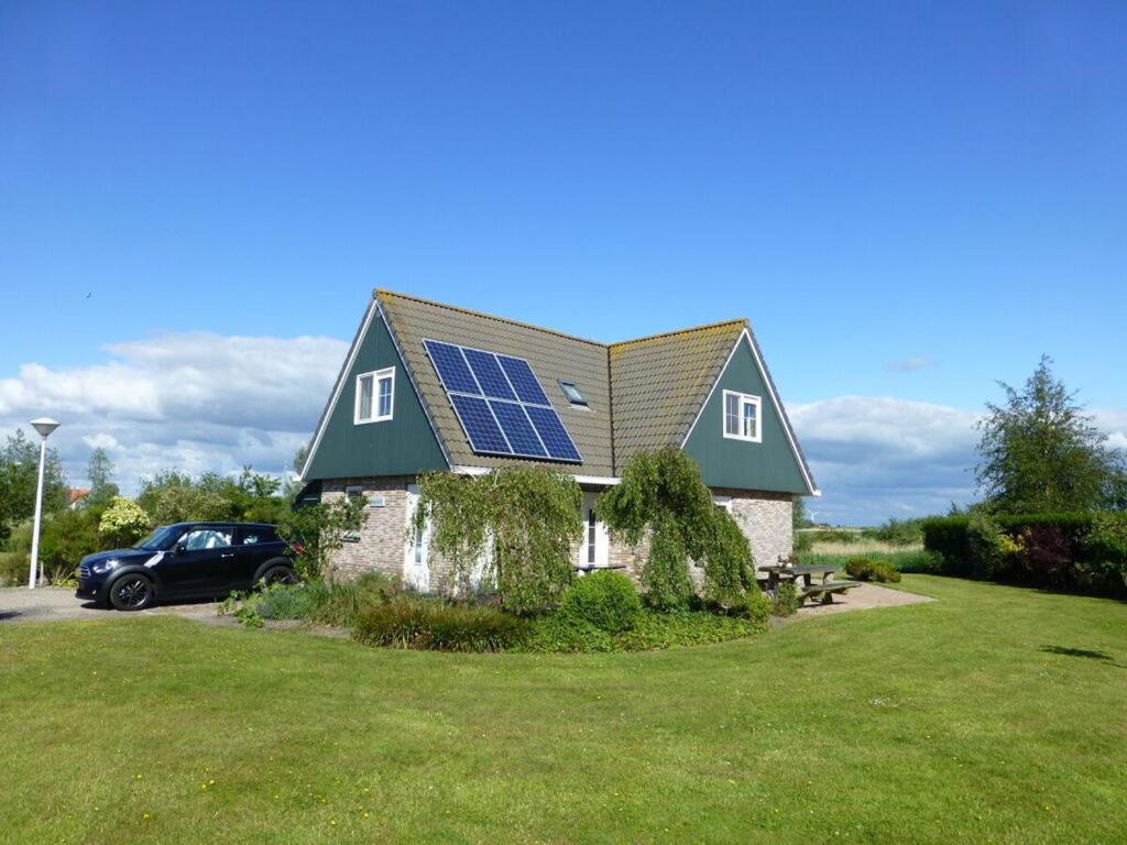 a house with a solar panel on top of it at Beachvilla Ijsselmeerblik in Makkum