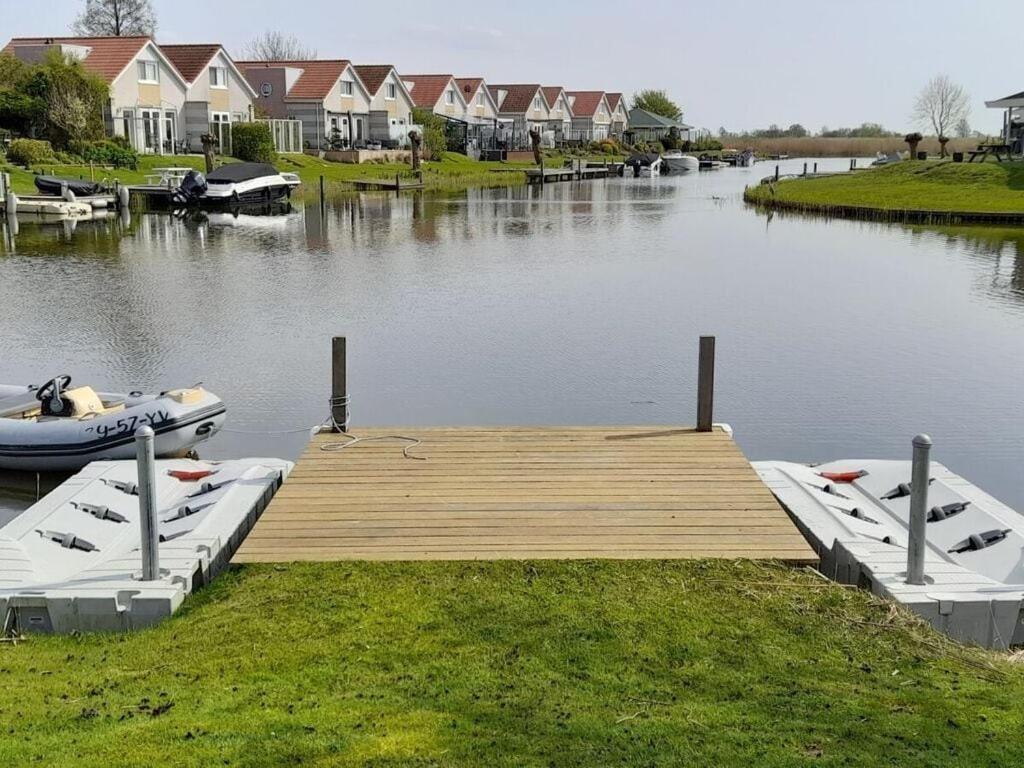 dos barcos están atracados en un muelle en un lago en Villa Sonnenschein, en Makkum