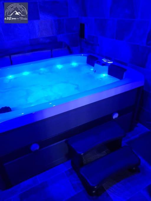- une salle de bains bleue pourvue d'une baignoire dans l'établissement Hébergement avec SPA privatif, à Loos-en-Gohelle