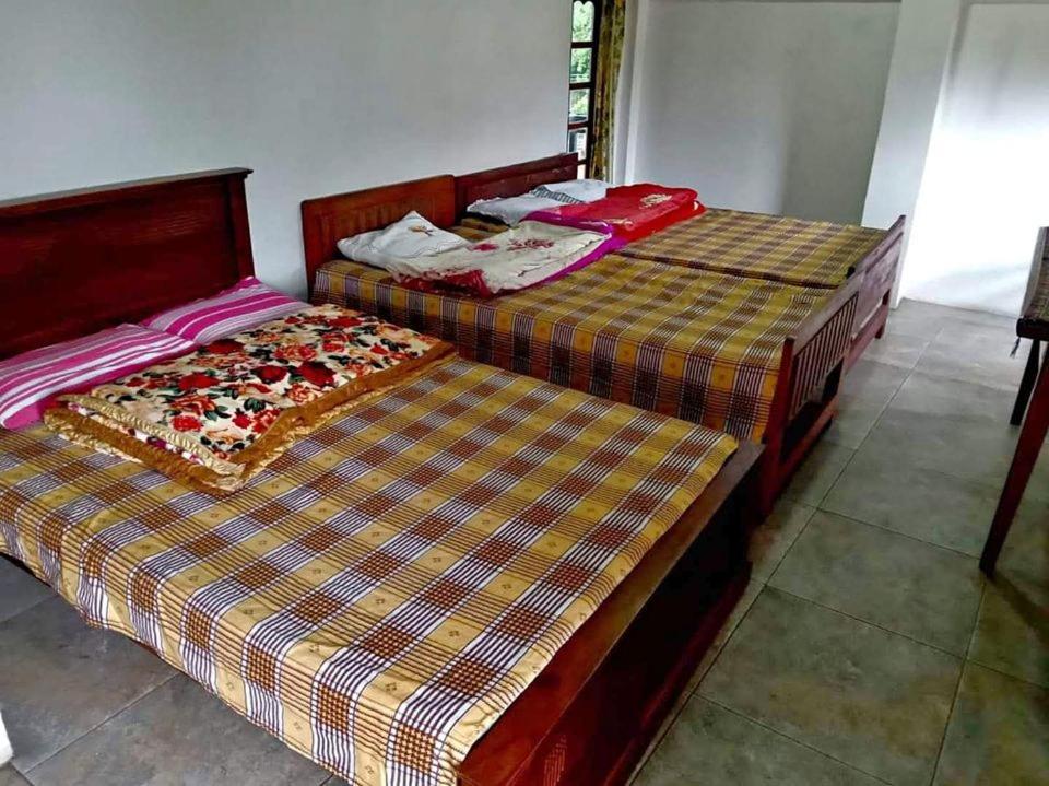 2 nebeneinander sitzende Betten in einem Schlafzimmer in der Unterkunft Sweety Forest Villa in Passara