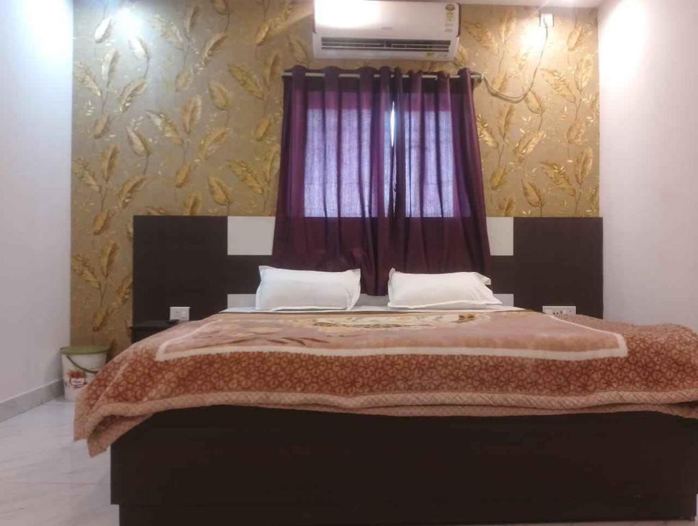 HazārībāgにあるHotel Alakhraj Palaceのベッドルーム1室(赤いカーテン付きの大型ベッド1台付)
