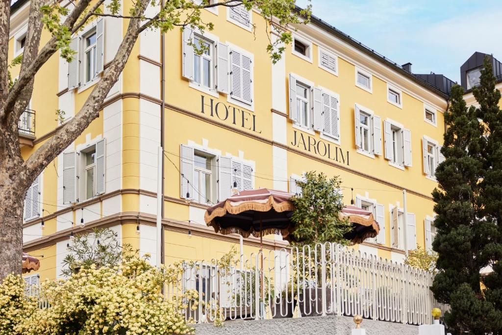 a yellow hotel with umbrellas in front of it at Hotel Jarolim in Bressanone