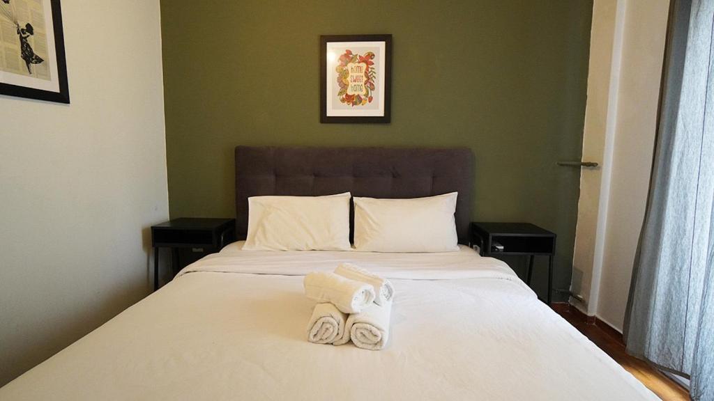 ein Schlafzimmer mit einem Bett mit zwei Handtüchern darauf in der Unterkunft Athens City Themis 7 in Athen