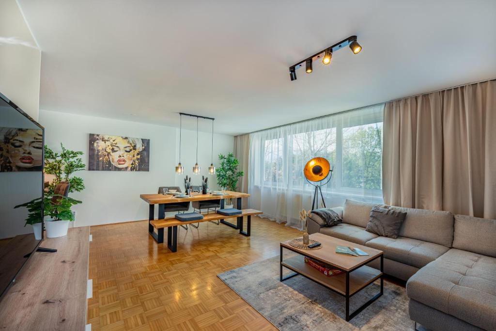 a living room with a couch and a table at Stadtapartments Luna by Cosy Homes in Villach