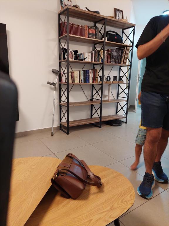 a man standing next to a table with a purse on it at משה לא פעיל in Afula