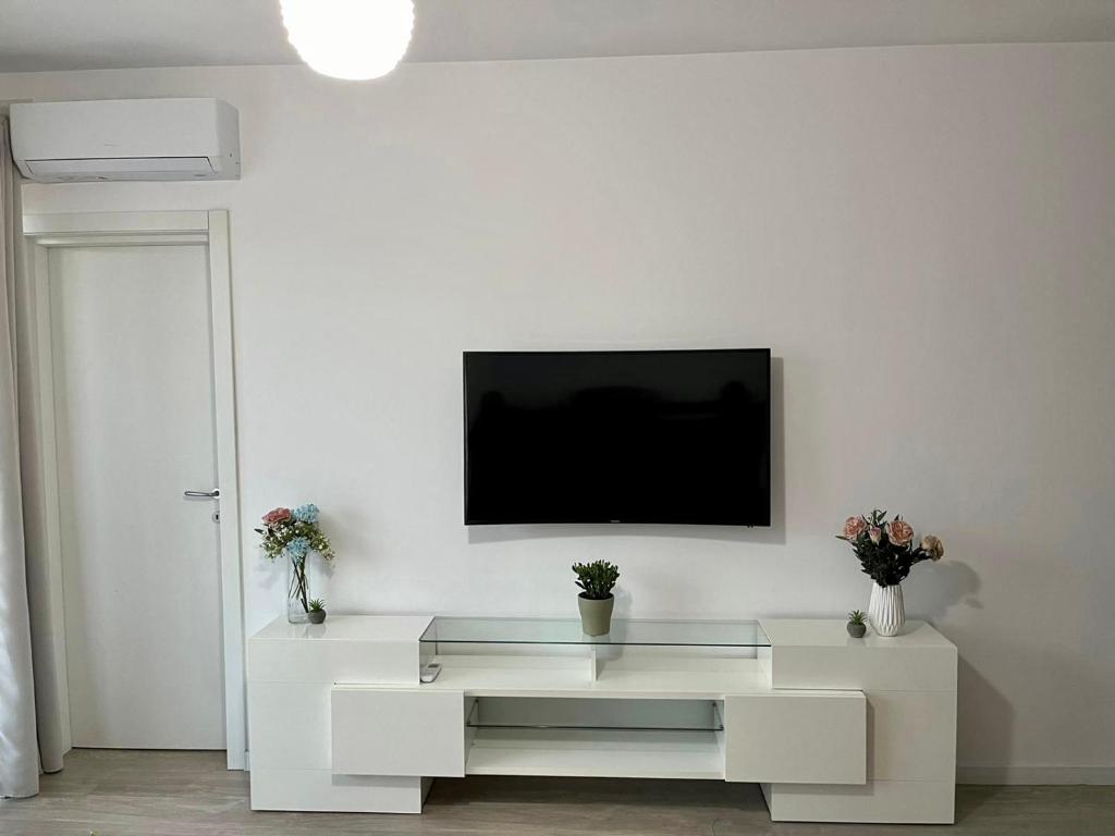 ein weißes Wohnzimmer mit einem TV an einer weißen Wand in der Unterkunft Universitatii Rooms in Oradea